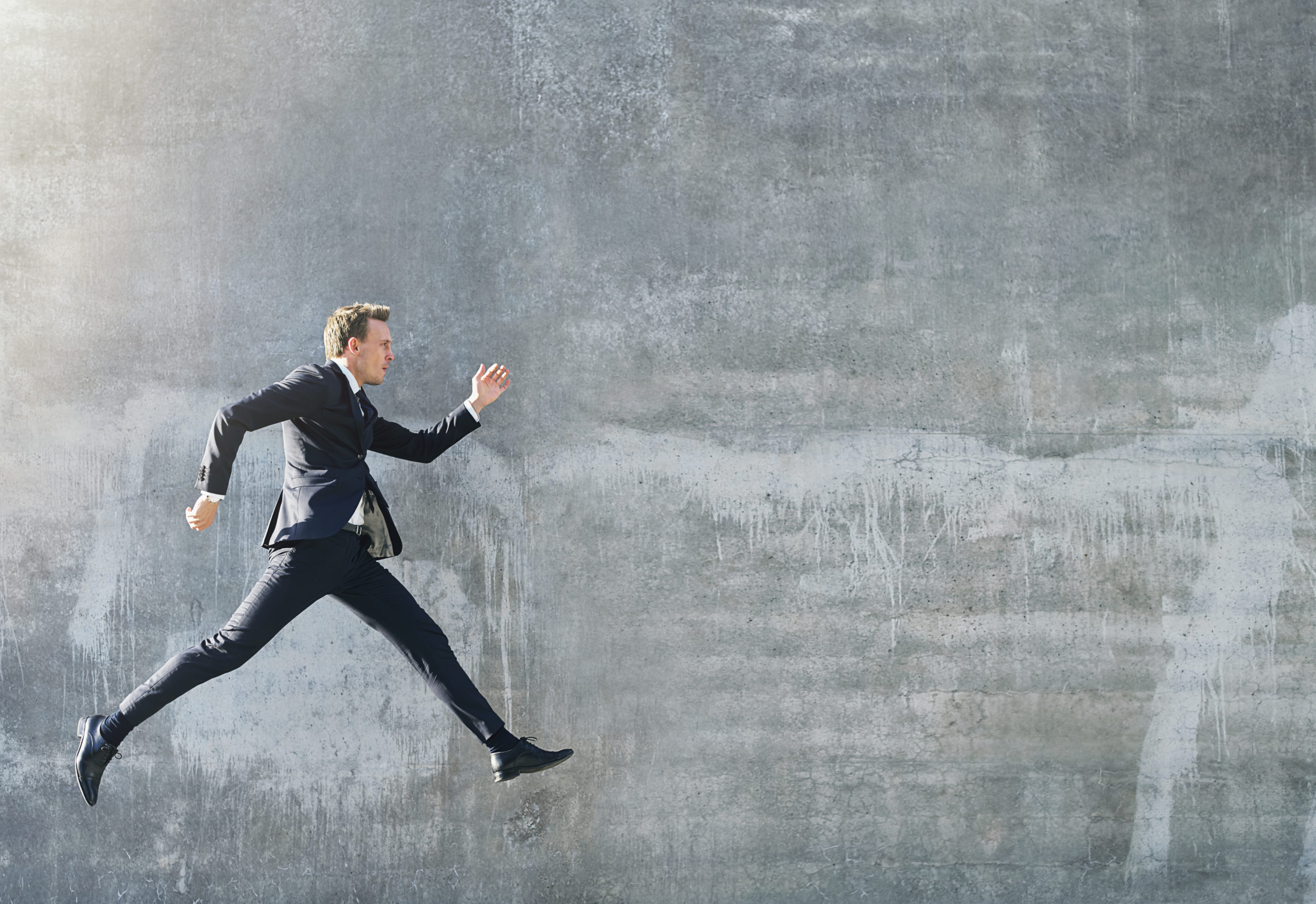 Man in dark suit walking in jump