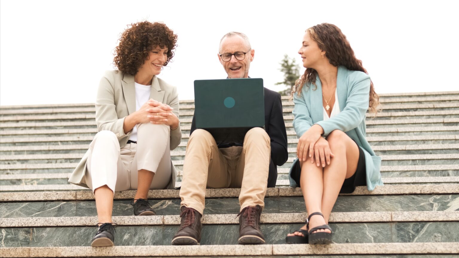Drei Mitarbeitende besprechen sich am Laptop