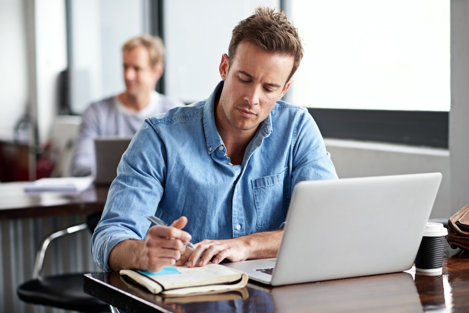 Mann arbeitet konzentriert am Laptop