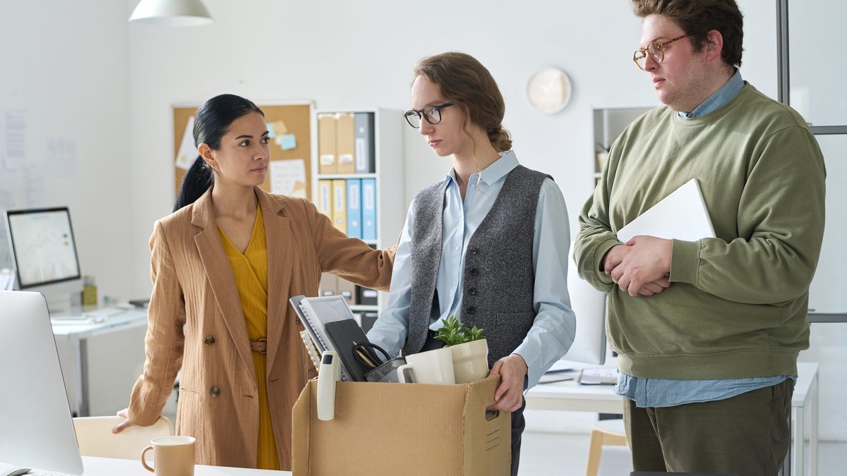 Mitarbeiterin verl&auml;sst das B&uuml;ro mit einem Karton