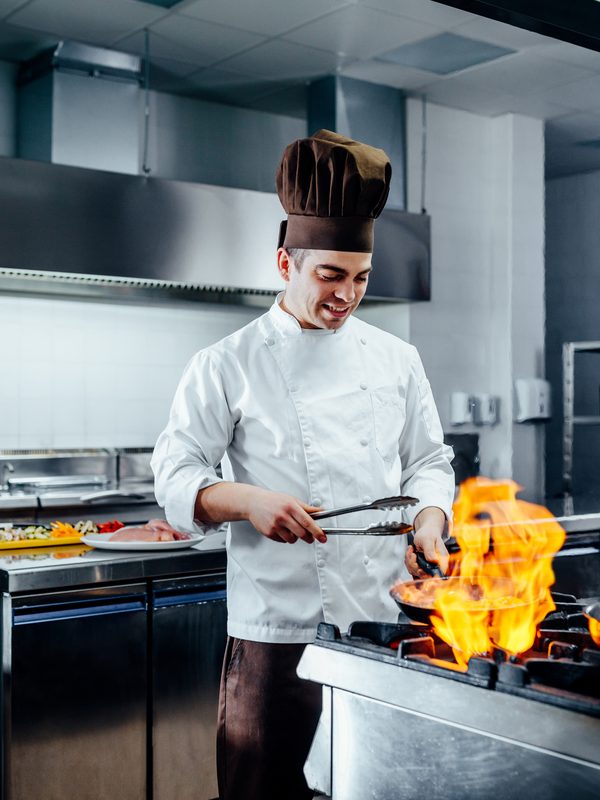 Koch flambiert in einer Hotelk&uuml;che